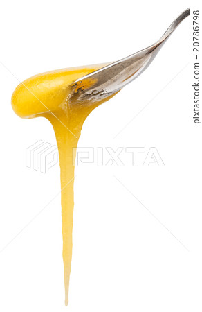 yellow honey flows down from teaspoon close up 20786798