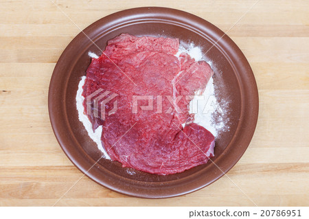 raw veal schnitzel breaded in flour on plate raw veal schnitzel breaded in flour on plate 20786951