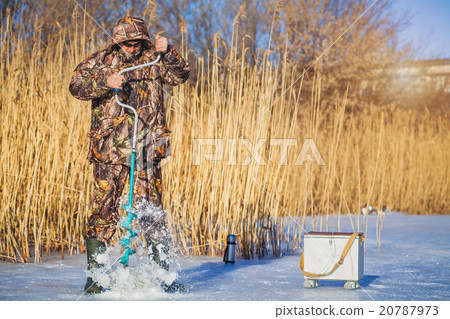 Ice fisherman drill on  winter lake 20787973