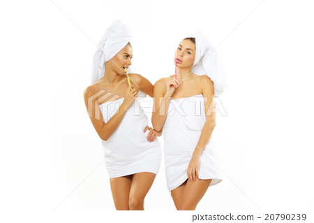Two girls brush their teeth after shower 20790239
