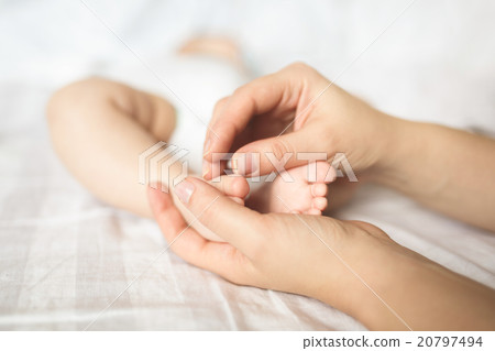 Baby feet in hands of mother 20797494