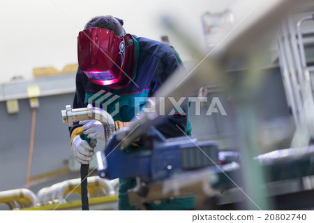 Industrial worker welding in metal factory. 20802740