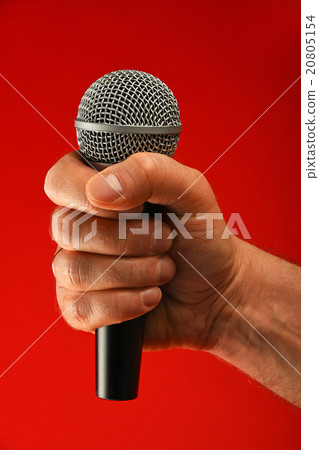 Man hand with microphone over red background 20805154