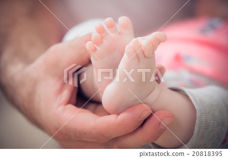 newborn baby feet in male hands 20818395