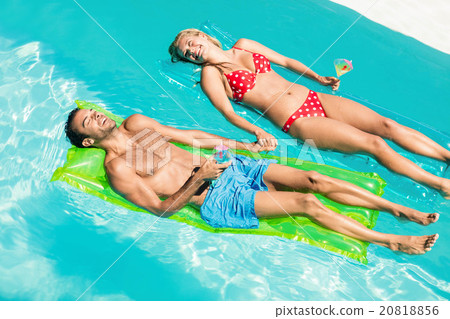 Peaceful couple on lilos holding cocktails Peaceful couple on lilos holding cocktails 20818856