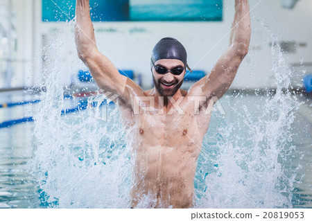 Smiling man triumphing with raised arms 20819053