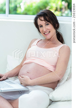 Pregnant woman relaxing with her laptop 20819084