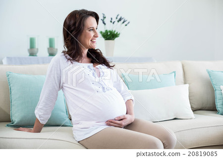 Pregnant woman sitting in the living room Pregnant woman sitting in the living room 20819085