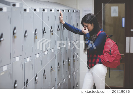 Stressed student beside her locker 20819086