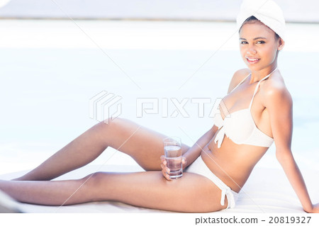 Smiling brunette holding glass of water 20819327