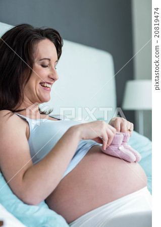Pregnant woman with knitted slippers on her belly 20819474