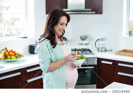 Pregnant woman eating salad Pregnant woman eating salad 20819480
