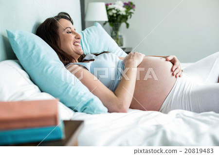 Pregnant woman lying on bed Pregnant woman lying on bed 20819483