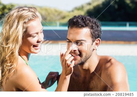 Girlfriend applying cream to boyfriend Girlfriend applying cream to boyfriend 20819485
