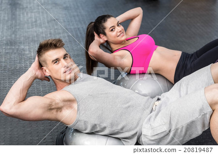 Athletic woman and man doing crunches Athletic woman and man doing crunches 20819487