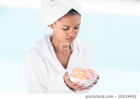 Peaceful brunette holding bowl of petals Peaceful brunette holding bowl of petals 20819492