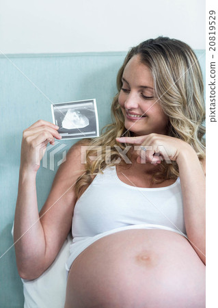 Pregnant woman showing an ultrasound picture 20819529