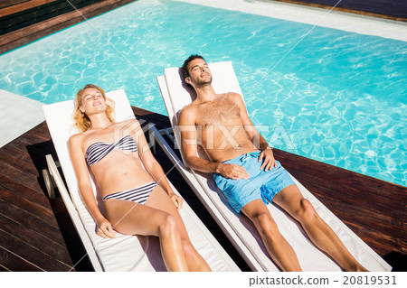 Cute couple relaxing on deckchairs 20819531
