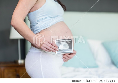 Pregnant woman showing ultrasound scan Pregnant woman showing ultrasound scan 20819543