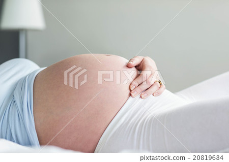 Pregnant woman resting on her bed 20819684