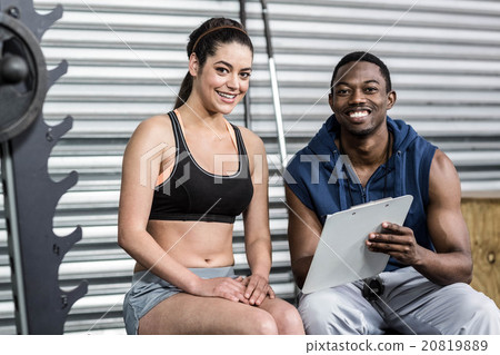 Athletic woman and trainer smiling to camera 20819889