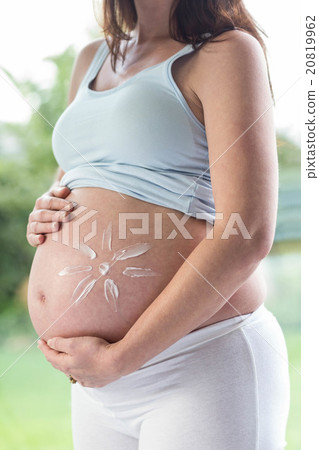 Pregnant woman applying cream on her belly Pregnant woman applying cream on her belly 20819962