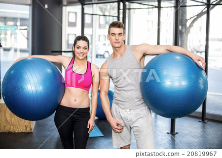 Fit couple posing with sport ball 20819967