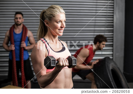 Portrait of fit woman lifting dumbbells 20820058