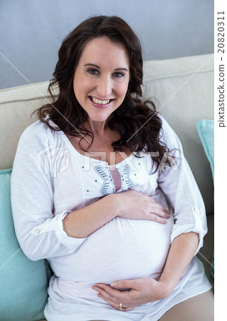 Pregnant woman sitting in the living room 20820311