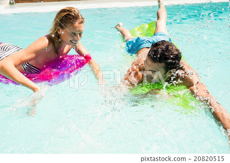 Happy couple on lilos splashing 20820515