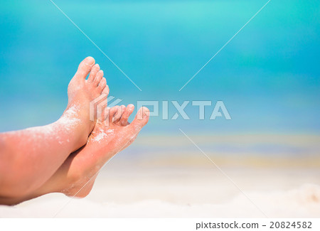 Close up of female feet on white sandy beach 20824582