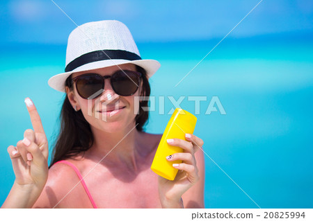 Young happy woman applying suntan lotion on her Young happy woman applying suntan lotion on her 20825994