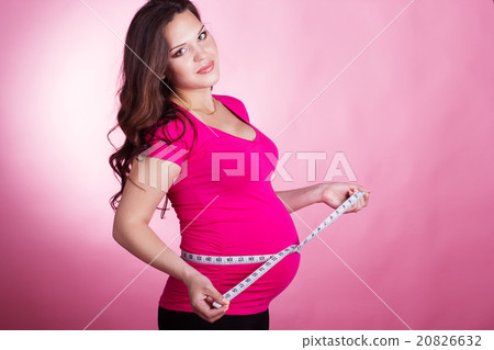 Happy pregnant woman with tape measure 20826632
