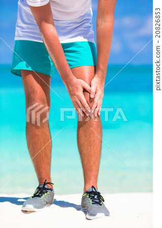 Male athlete suffering from pain in leg while 20826853