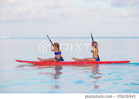 Little girls swimming on surfboard during summer 20826945