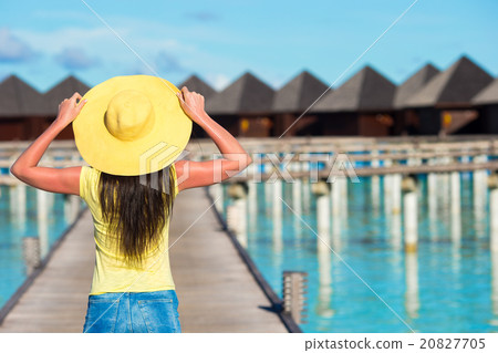 Beautiful woman walking to water bungalow at Beautiful woman walking to water bungalow at 20827705