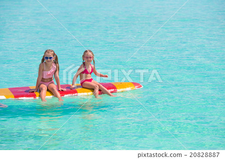 Little adorable girls on a surfboard in the 20828887