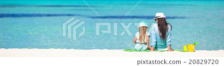 Little girl and young mom relaxing at beach Little girl and young mom relaxing at beach 20829720
