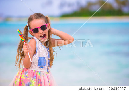 Adorable little girl have fun with lollipop on the Adorable little girl have fun with lollipop on the 20830627