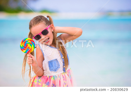 Adorable little girl have fun with lollipop on the Adorable little girl have fun with lollipop on the 20830629