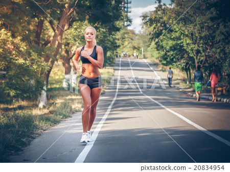 young woman jogging in the park in summer 20834954
