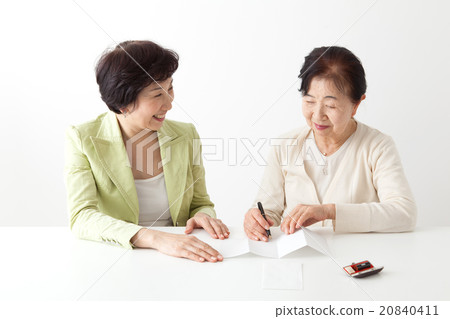 填寫文件的資深婦女和中間婦女 填寫文件的資深婦女和中間婦女 20840411