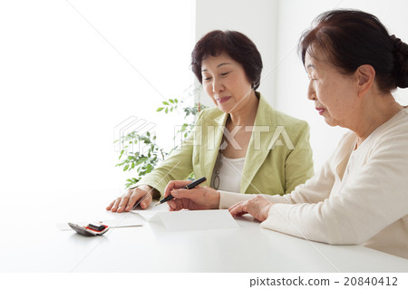 填寫文件的資深婦女和中間婦女 填寫文件的資深婦女和中間婦女 20840412