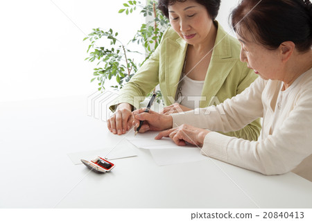 填寫文件的資深婦女和中間婦女 填寫文件的資深婦女和中間婦女 20840413