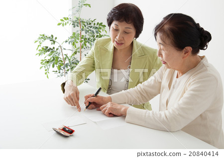 Senior women and middle women filling in documents 20840414