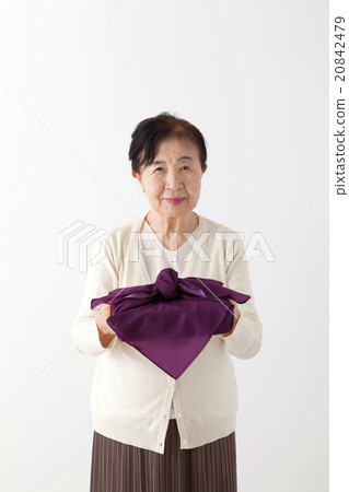 Senior women with box of wrapping packets 20842479