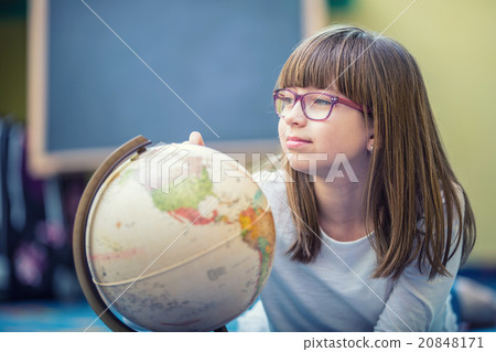 Pretty little student girl studying geography with 20848171