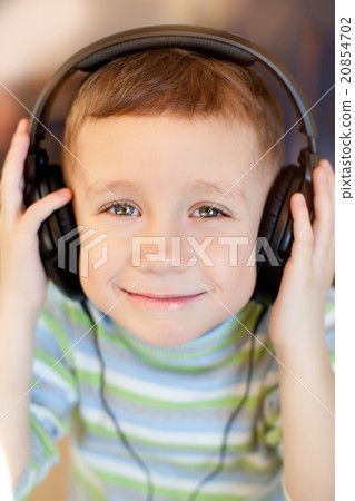 the child listens to music via earphones the child listens to music via earphones 20854702