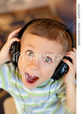 the child listens to music via earphones 20854703