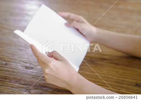 Hands open book on wood table Hands open book on wood table 20856641